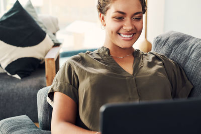 Portrait of smiling young woman using phone