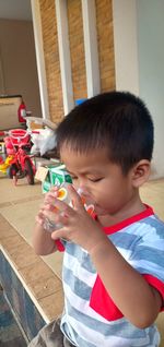 Boy having drink in glass while sitting at home