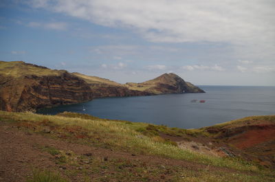 Scenic view of sea and mountains against sky