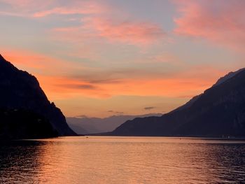 Scenic view of sea and mountains against sky during sunset