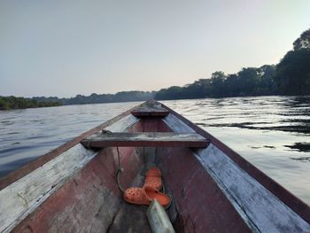 Man on boat against lake against clear sky