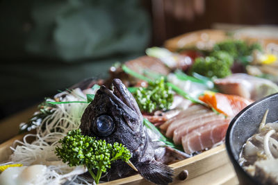 Noodles and fish on tray at restaurant