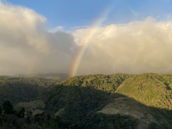 Scenic view of rainbow over land against sky