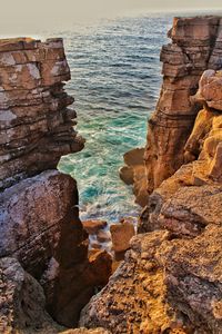 Rocks on sea shore against sky