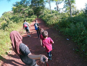 Rear view of people against plants