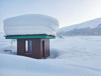 Built structure on snow covered mountain against sky