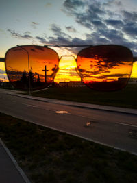 View of street during sunset seen through car window