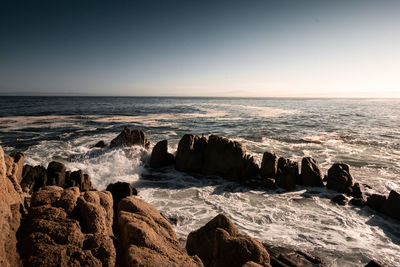 Scenic view of rocks in sea against sky