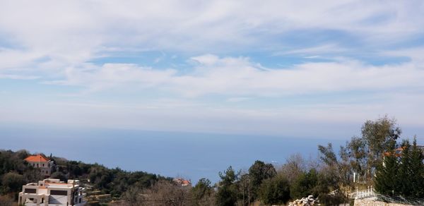 High angle view of townscape by sea against sky