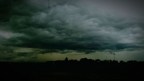 Silhouette of landscape against cloudy sky