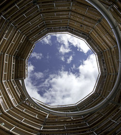 View of sky through large cylindrical wooden tower with internal tube slide