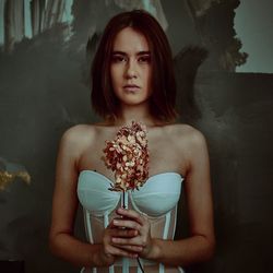 Portrait of young woman holding flower