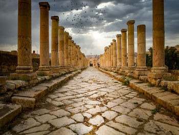 View of colonnade in city against sky