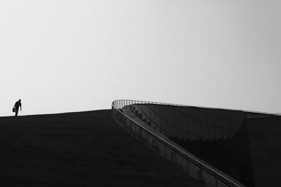 Man walking on road against clear sky