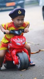 Portrait of boy playing with toy on road