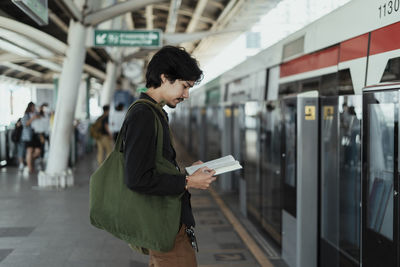 Rear view of woman standing by train