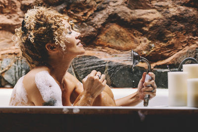 Smiling woman bathing in tub