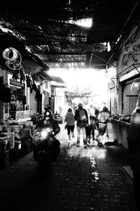 People walking on illuminated street at night