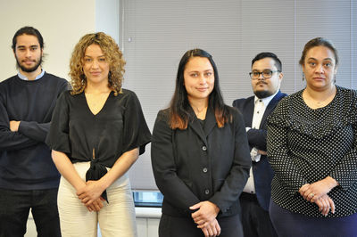 Portrait of business colleagues standing against wall