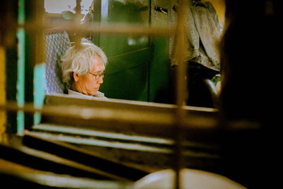 Senior man at home seen through window