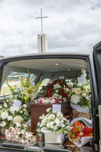 Closeup shot of a funeral casket or coffin in a hearse or chapel or burial at cemetery
