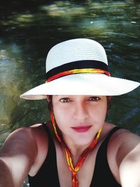 High angle portrait of woman wearing hat swimming in lake