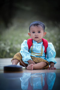 Portrait of cute boy sitting on table