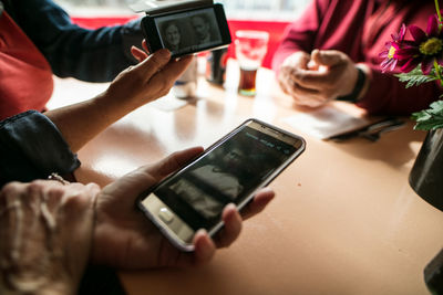 Midsection of man using mobile phone on table