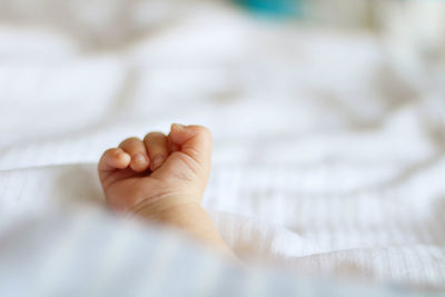 Close-up of baby hand on bed