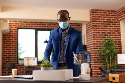 Man standing by potted plant on table