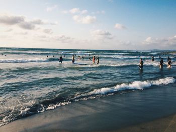 People at beach against sky