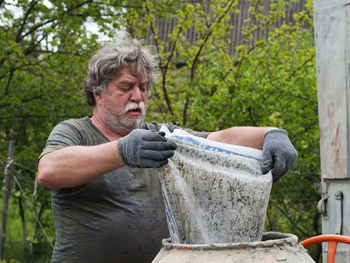 Man holding umbrella in yard