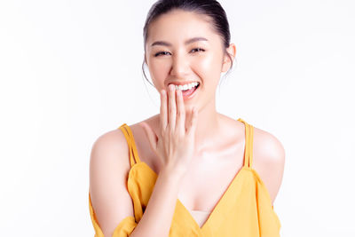 Portrait of smiling young woman against white background