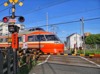 Train by railroad tracks against clear blue sky