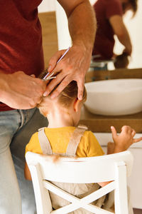 Dad cutting hair to little son
