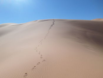 Sand dunes in desert against clear sky