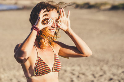 Cheerful woman wearing toys at beach