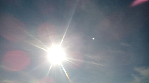 Low angle view of sun shining in sky