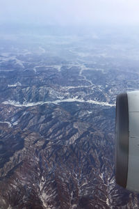 Cropped jet engine flying above mountains