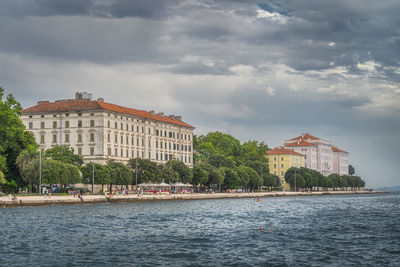 Buildings in city against cloudy sky