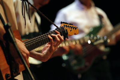 Midsection of man playing guitar