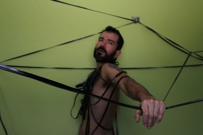 Portrait of young woman standing against rope