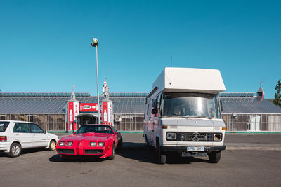 Cars on street against clear blue sky