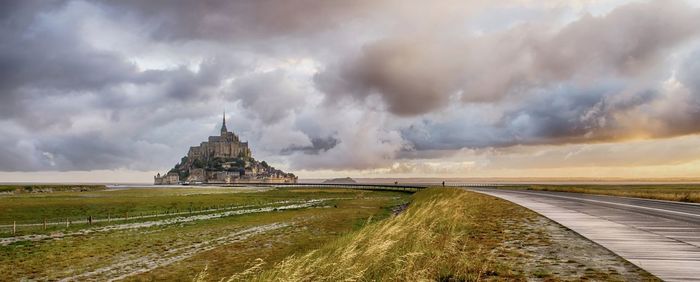 Panoramic view of temple on field against cloudy sky