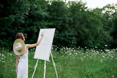 Rear view of woman standing on field