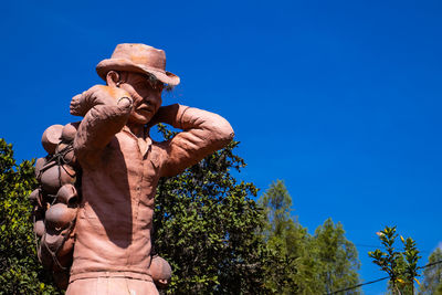 Low angle view of statue against blue sky