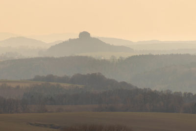Scenic view of landscape against sky during foggy weather