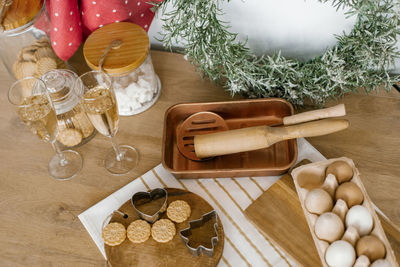 Christmas flat lay. ginger cookies and molds on a wooden board, champagne glasses, rolling pins