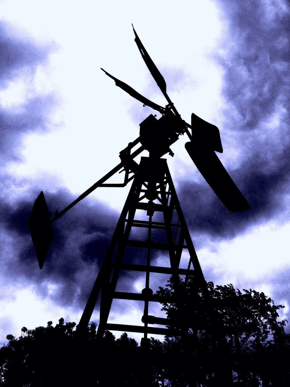 low angle view, sky, cloud - sky, cloudy, silhouette, cloud, environmental conservation, windmill, wind power, fuel and power generation, tall - high, alternative energy, traditional windmill, tree, renewable energy, no people, wind turbine, outdoors, built structure, day