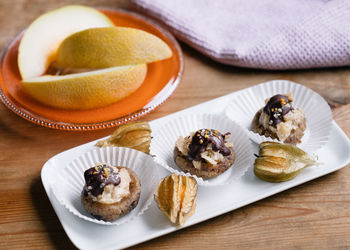 High angle view of dessert in cupcake holders on plate at table